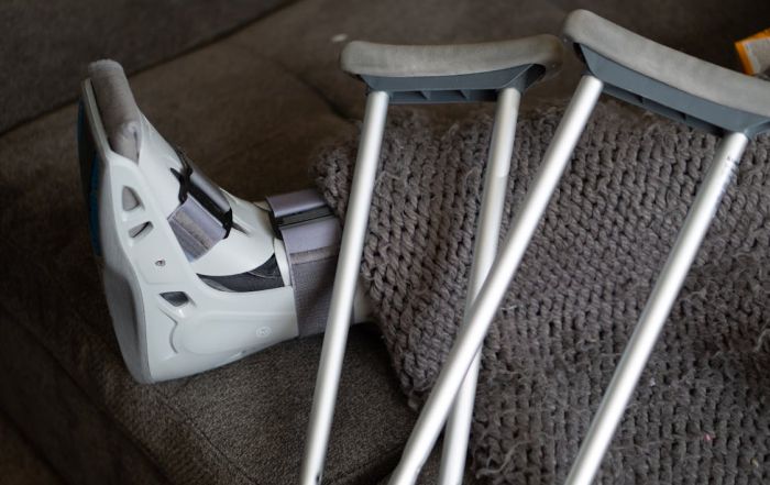 close-up of foot in walking brace and crutches