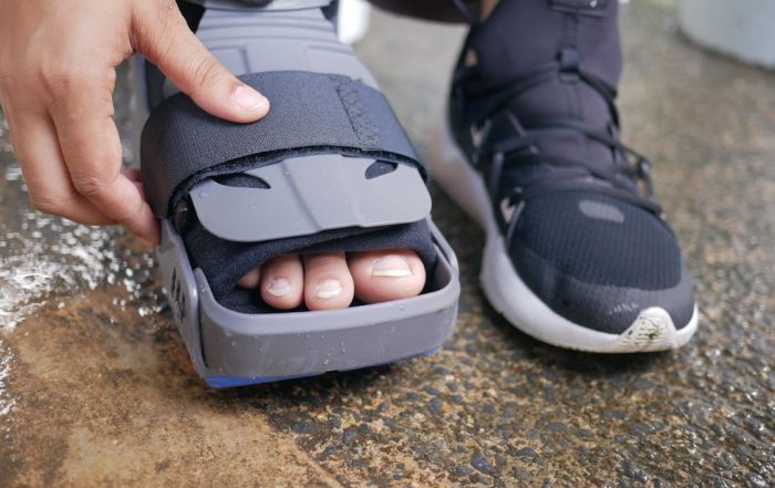 up-close view of person adjusting foot brace on injured leg