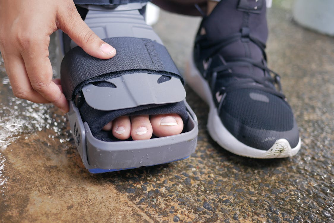 up-close view of person adjusting foot brace on injured leg