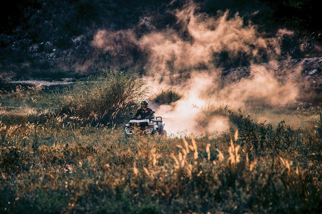 person riding ATV through field